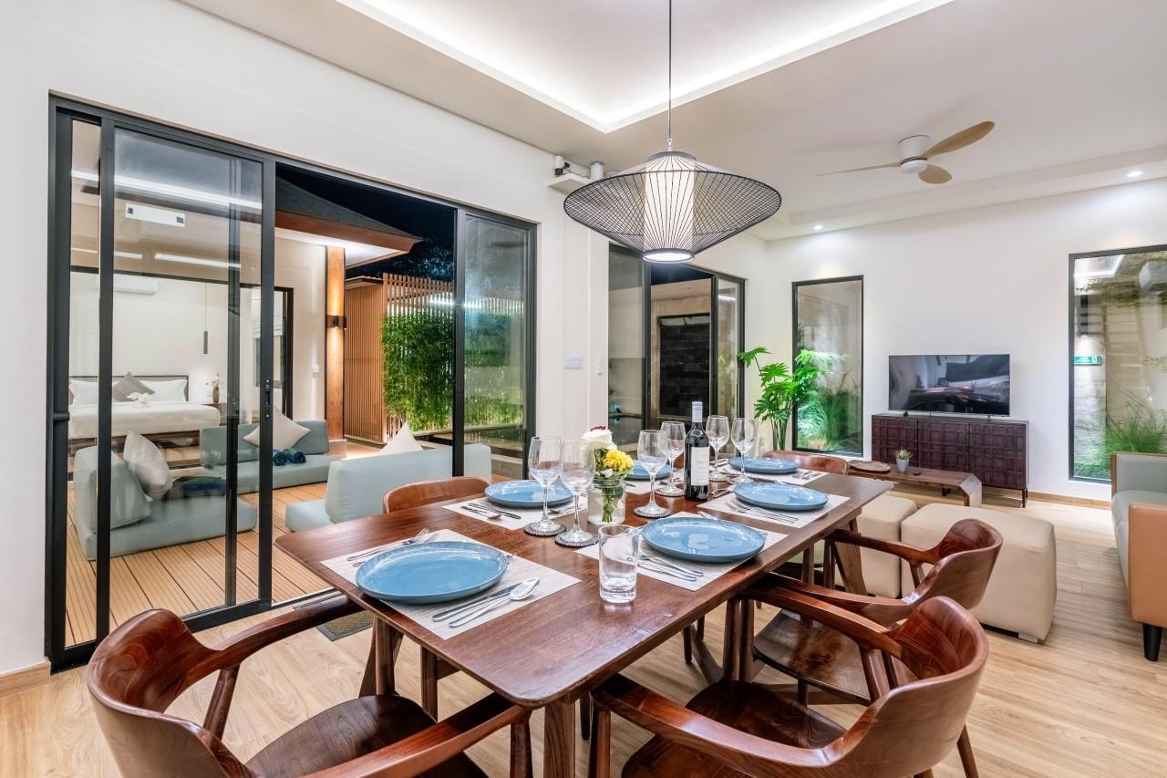 The dining table laid for six in the evening, pendant lit